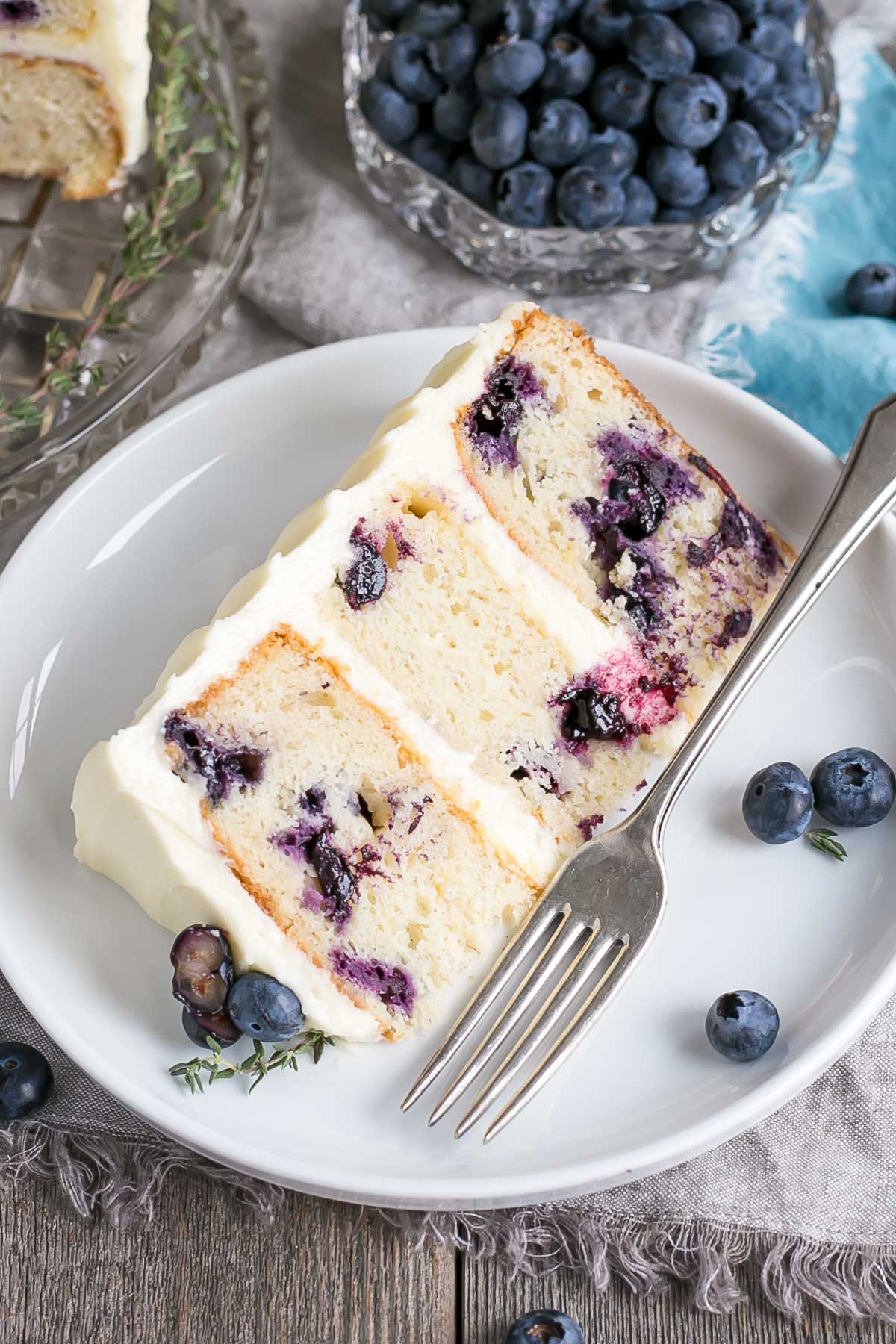 Blueberry Banana Cake! The delicious combination of bananas and blueberries gets paired with a tangy cream cheese frosting in this Blueberry Banana Cake recipe. | livforcake.com A cut slice of this Blueberry Banana Cake recipe.