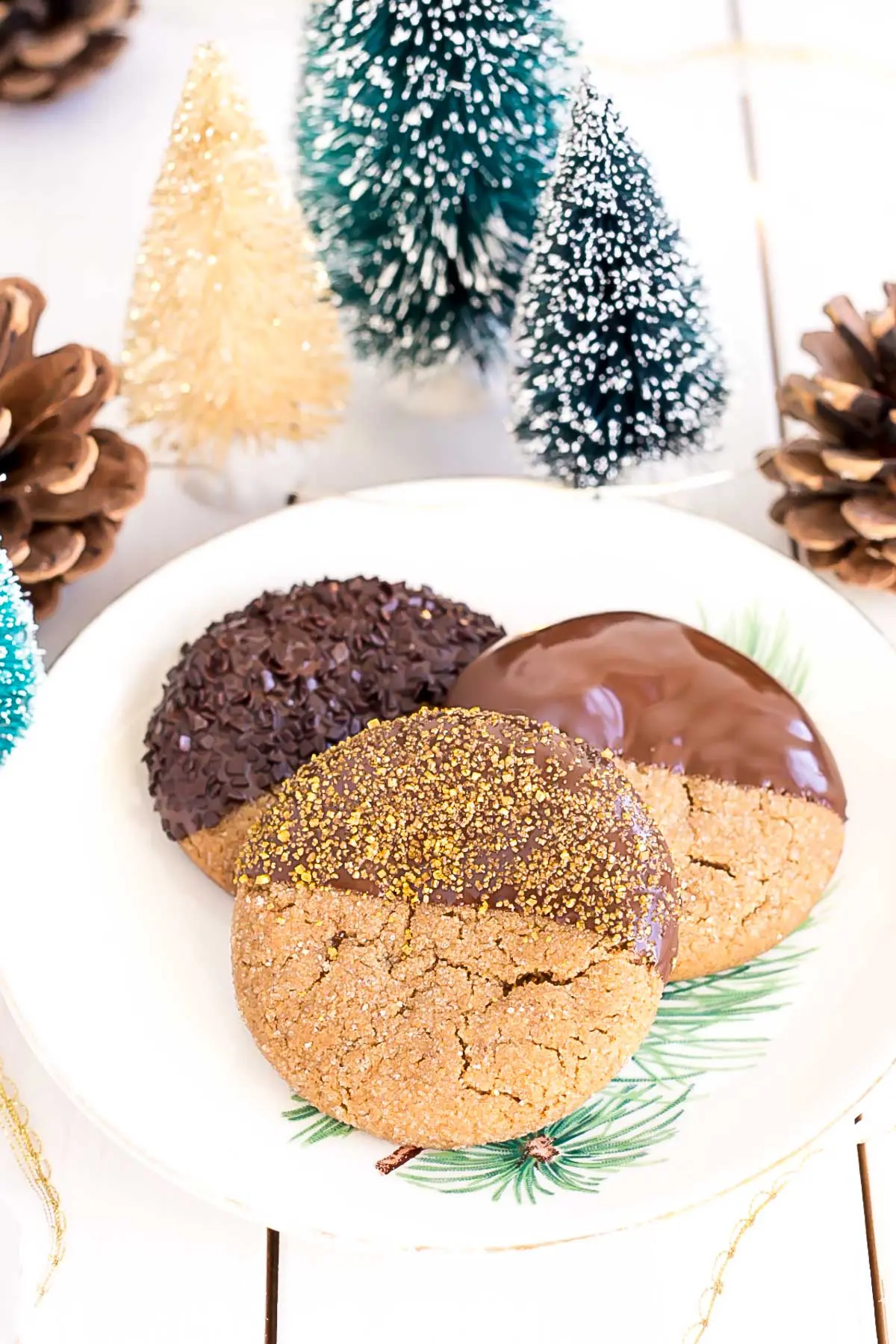 These Chocolate Dipped Gingerbread Cookies are the perfect treat for the holiday season! Chewy ginger spiced cookies dipped in dark chocolate. | livforcake.com Three cookies on a plate