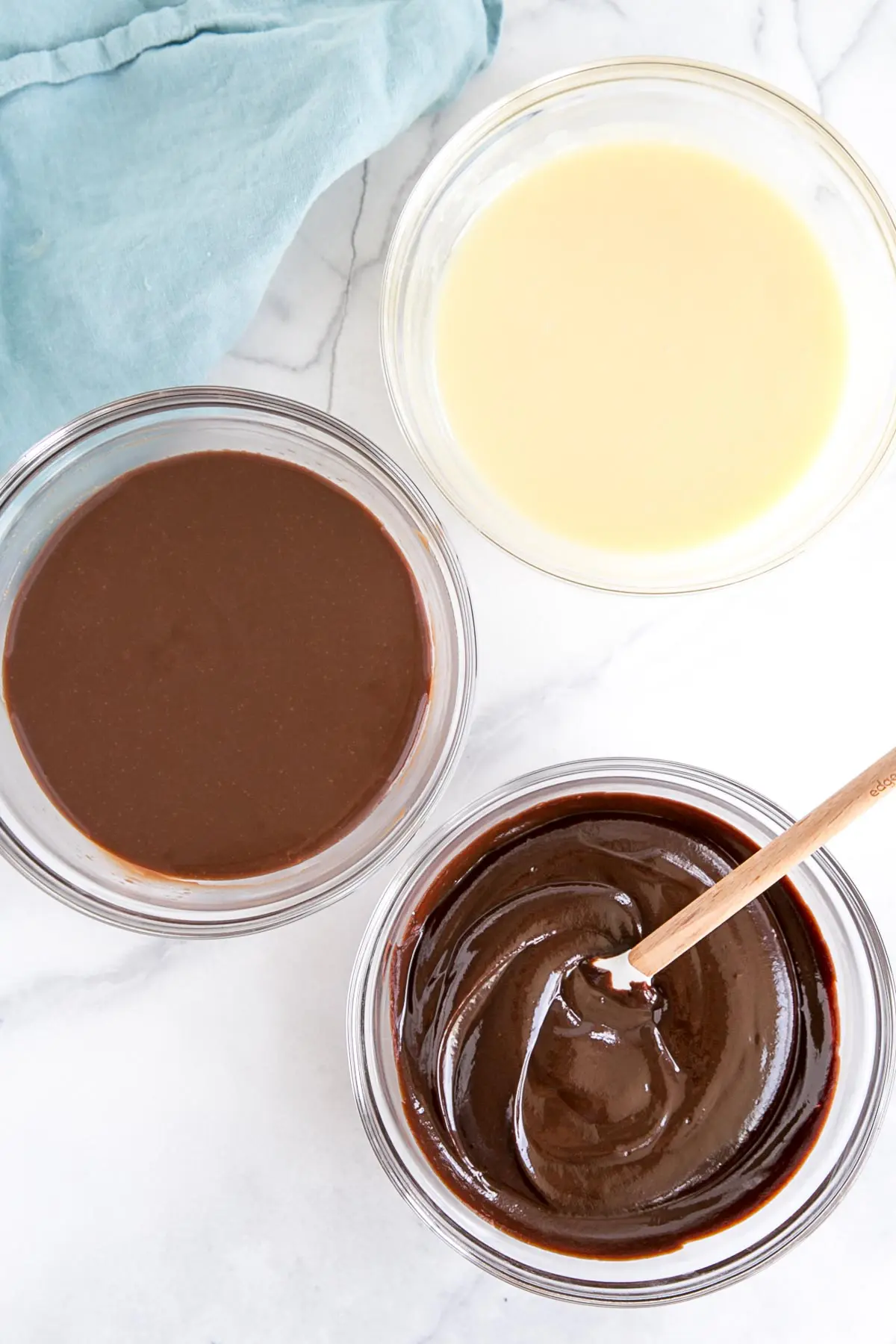 How to make Chocolate Ganache! A simple, two-ingredient recipe for a delicious frosting, filling, drip, or glaze. | livforcake.com Three bowls of ganache -- white, milk, and dark.
