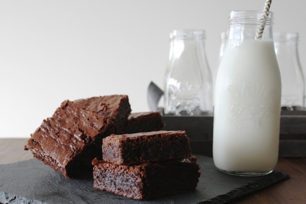 Stack of brownies with a glass of milk.
