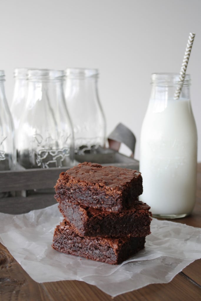Stack of brownies with a glass of milk.
