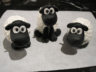 A close up of three fondant sheep.
