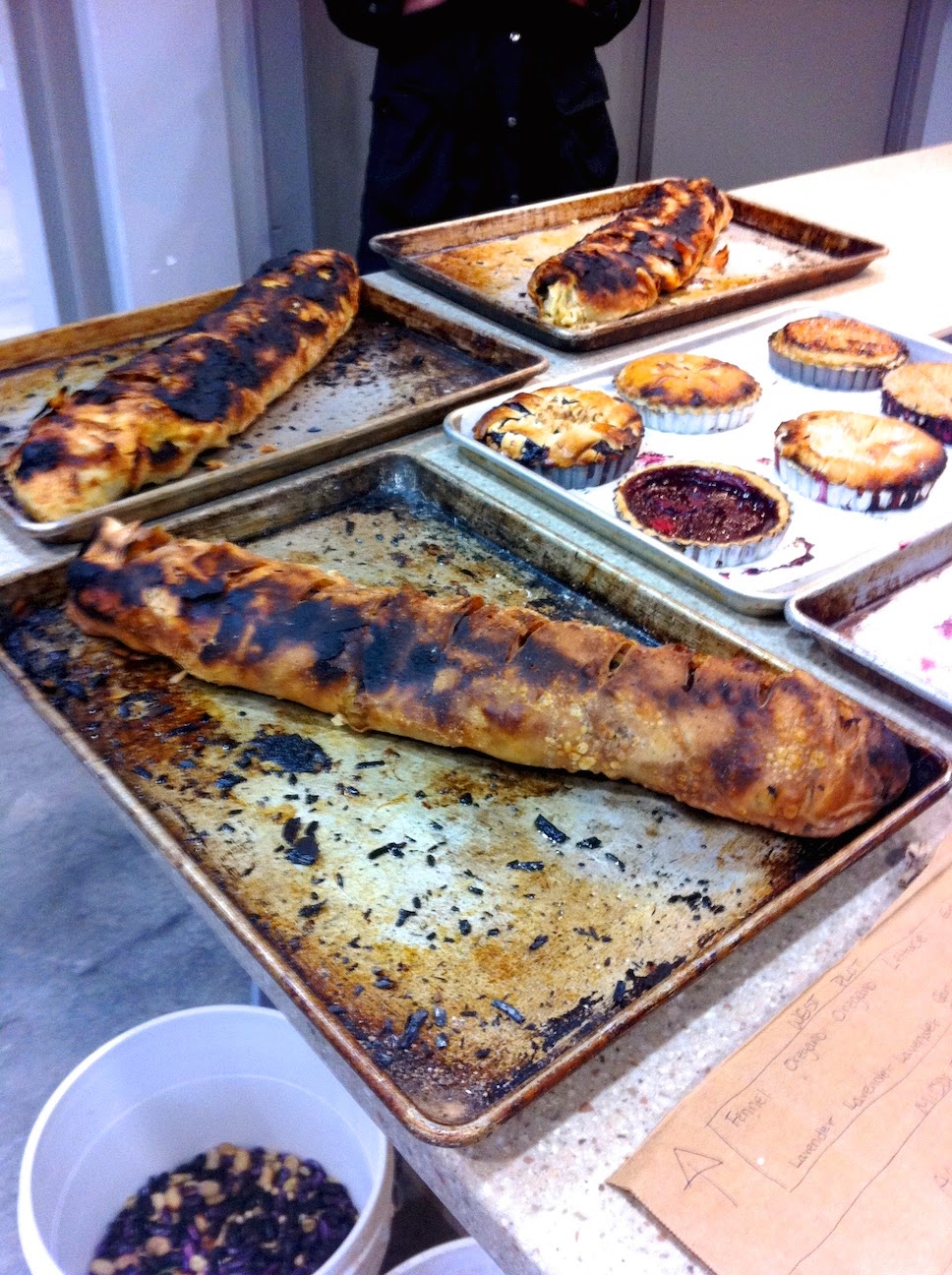 Various baked goods in the pastry kitchen.A pizza sitting on top of a table
