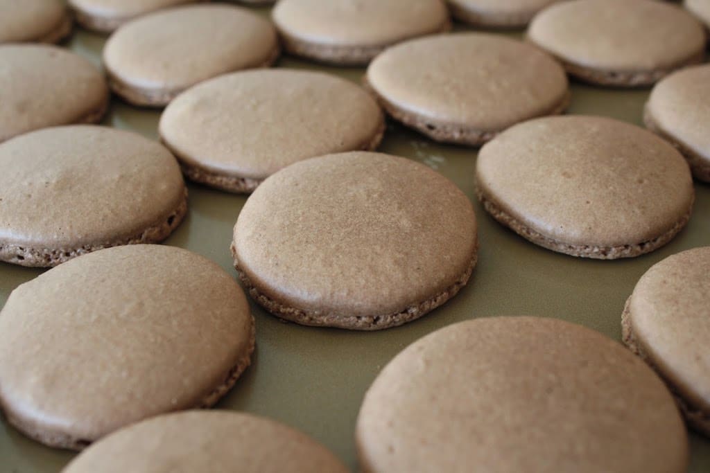 Macaron shells on a baking sheet.