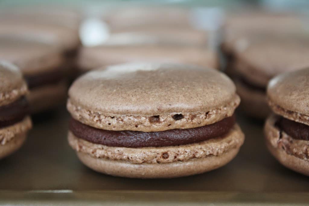 A close up of a chocolate macaron
