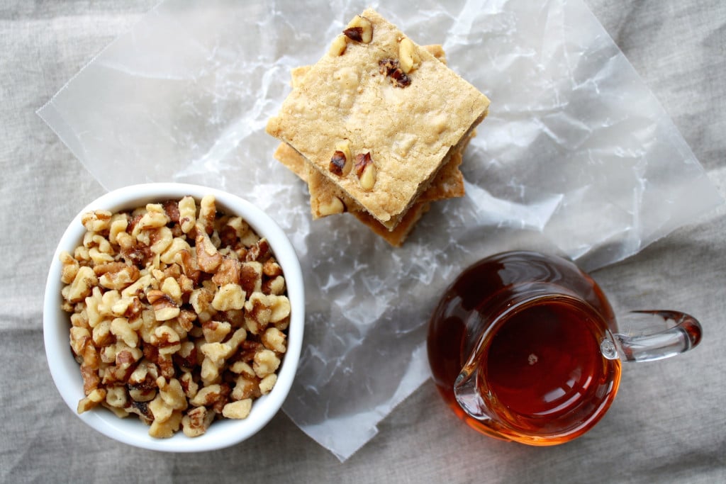 Overhead of a maple bar with a bowl of walnuts.
