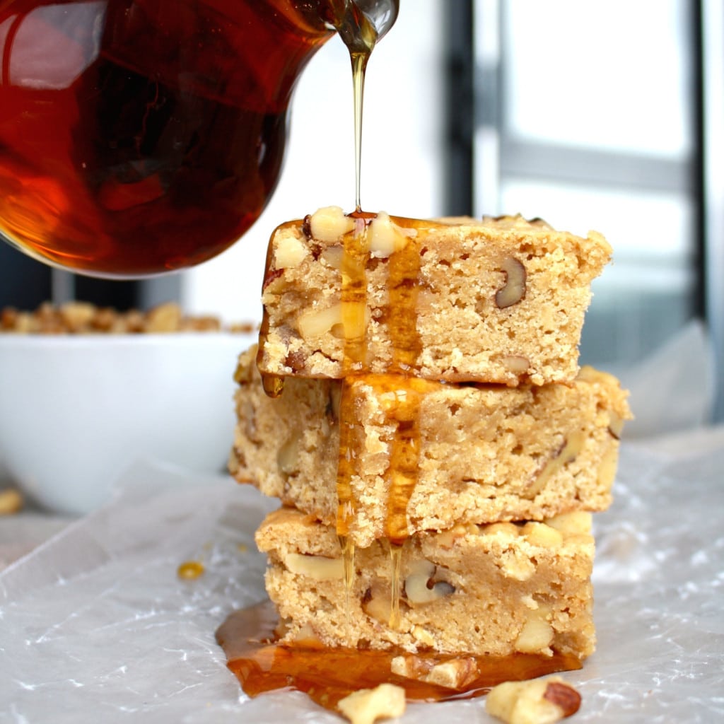 Stack of maple bars with maple syrup being drizzled on top.