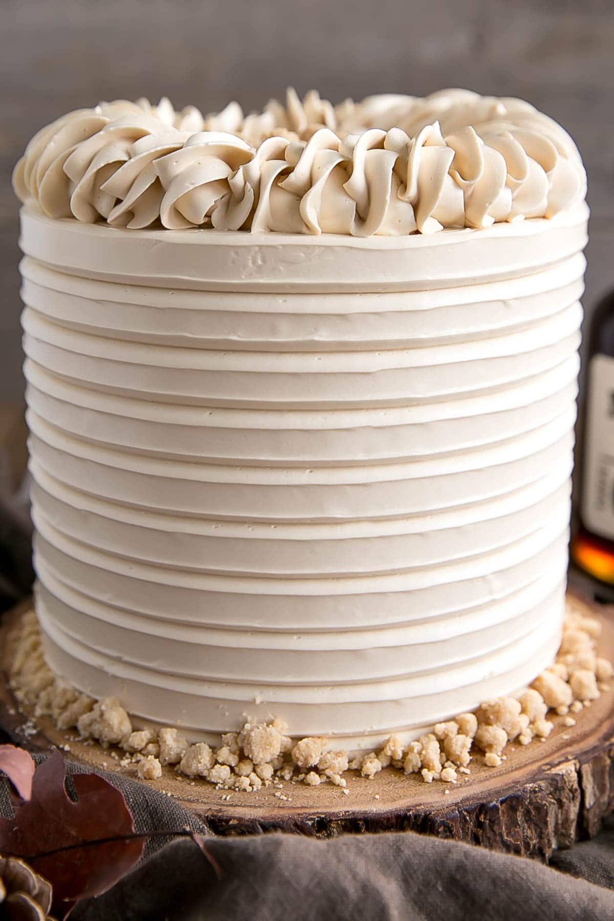 This Maple Cake is packed with pure, natural maple flavour throughout. Maple cake layers with a maple buttercream and maple streusel. | livforcake.com Close up of Maple Cake showing textured frosting and rope border.