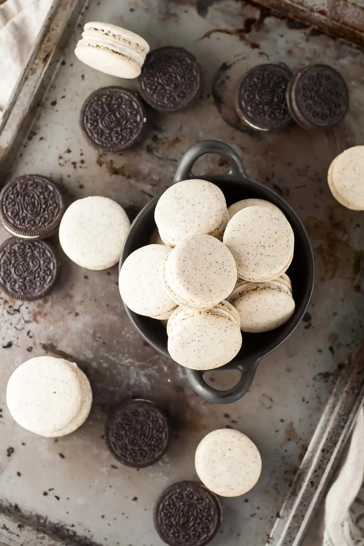 Oreo Macarons! Turn your favourite store-bought classics into something more decadent with these delicate Oreo macarons. | livforcake.com Overhead image of oreo macarons on a baking sheet.