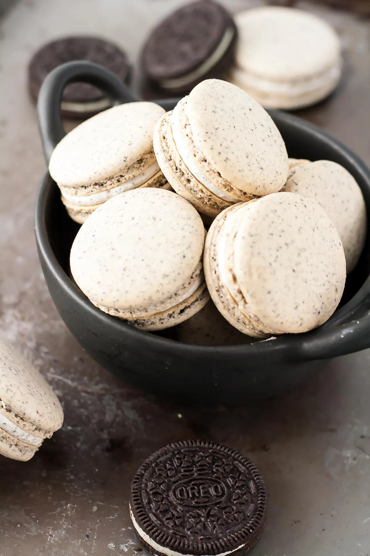 Oreo Macarons! Turn your favourite store-bought classics into something more decadent with these delicate Oreo macarons. | livforcake.com Close up of macarons in a bowl.