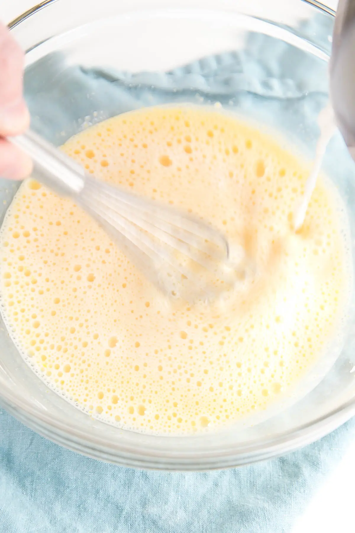 This easy Pastry Cream (Creme Patissiere) recipe is simple and delicious. A rich and creamy vanilla custard you can use in a variety of decadent desserts. | livforcake.com Egg mixture being tempered with hot milk.