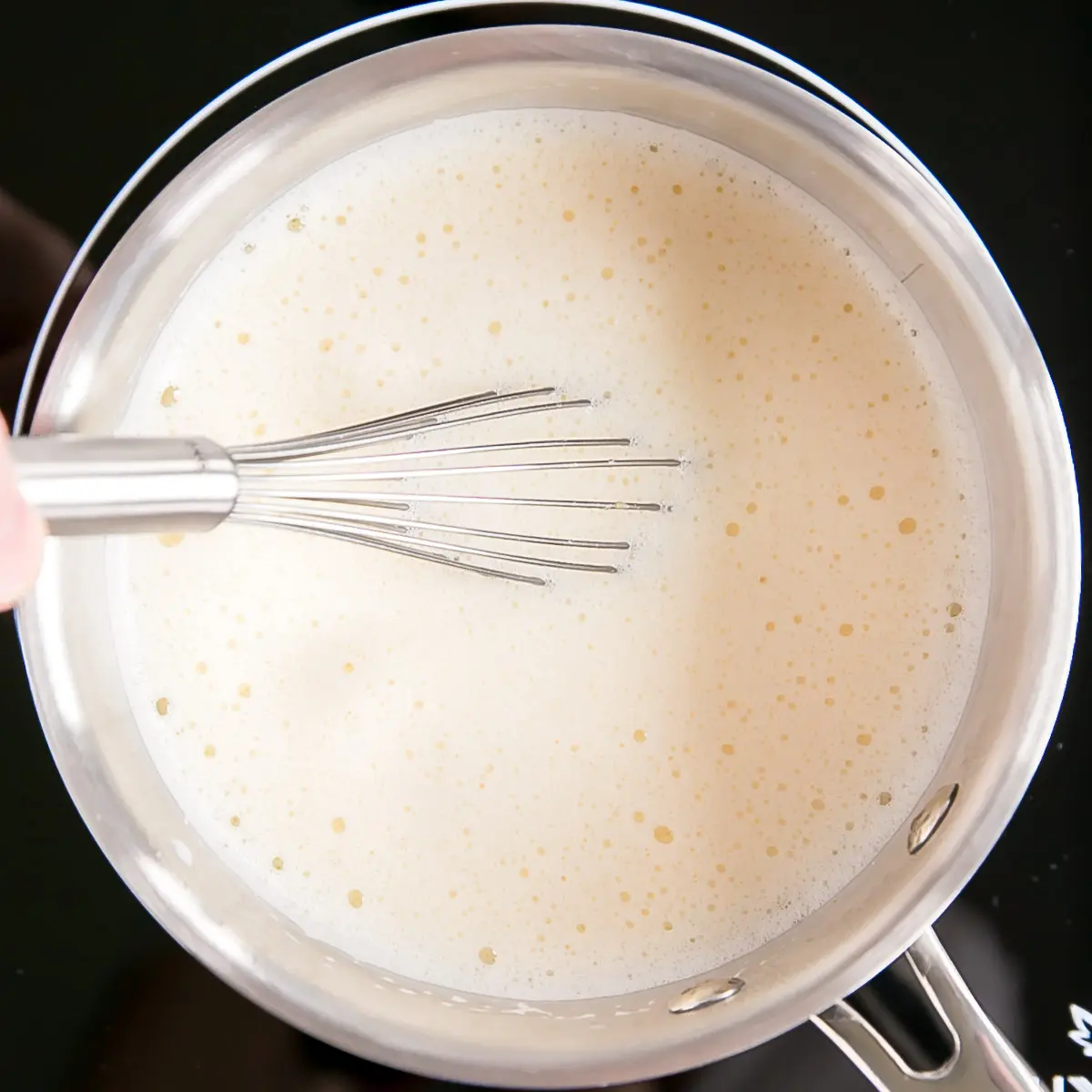 This easy Pastry Cream (Creme Patissiere) recipe is simple and delicious. A rich and creamy vanilla custard you can use in a variety of decadent desserts. | livforcake.com Tempered custard back in the pot on the stove.