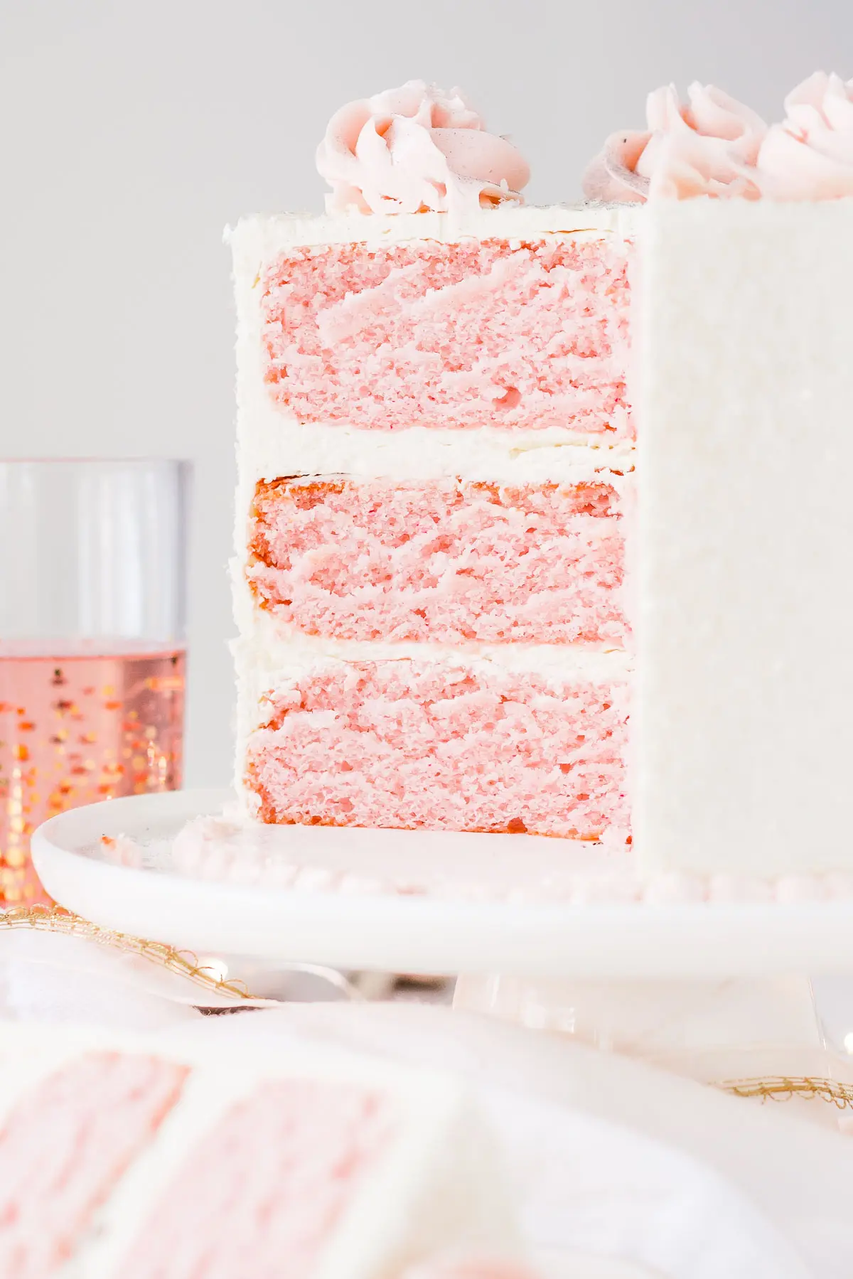 This Pink Champagne Cake is the perfect way to celebrate any occasion or holiday! A champagne infused cake with a classic vanilla buttercream. | livforcake.com Cross section of pink champagne cake with vanilla buttercream.