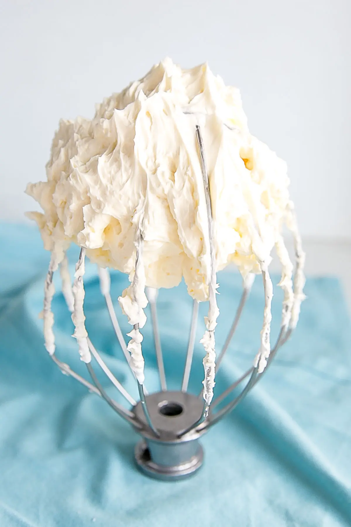 This tutorial on how to make Swiss Meringue buttercream is the only resource you'll need to make the smoothest, silkiest frosting! | livforcake.com Swiss meringue buttercream on a stand mixer whisk.