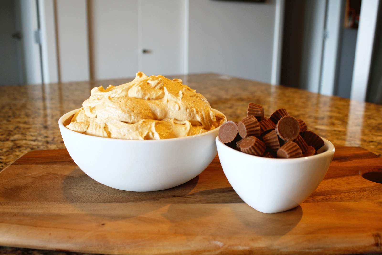 Frosting and mini Reese\'s in a bowl.